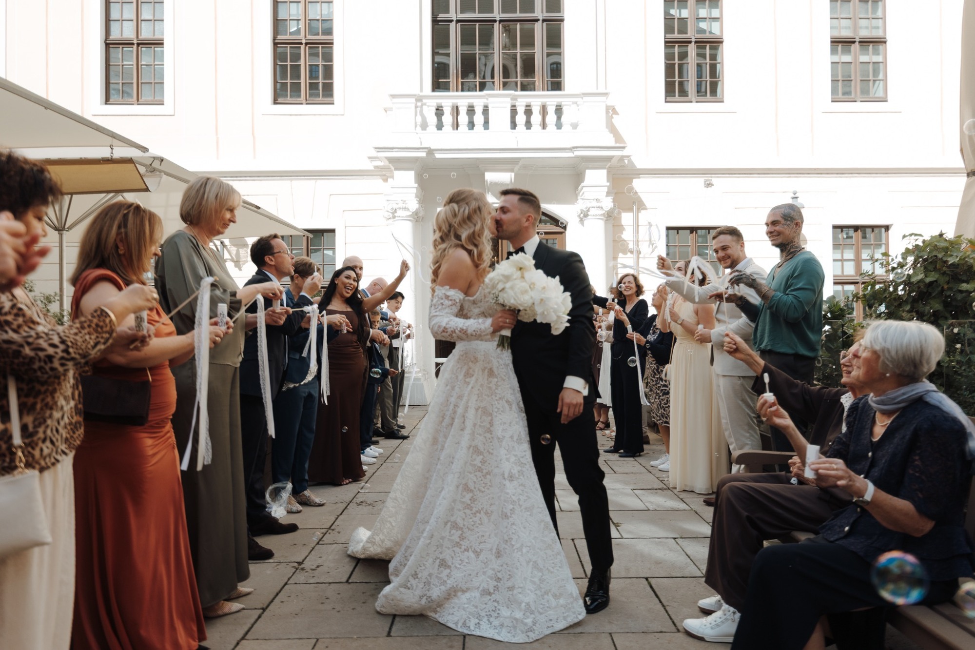 Christine und Max werden im Innenhof von ihren Gästen empfangen