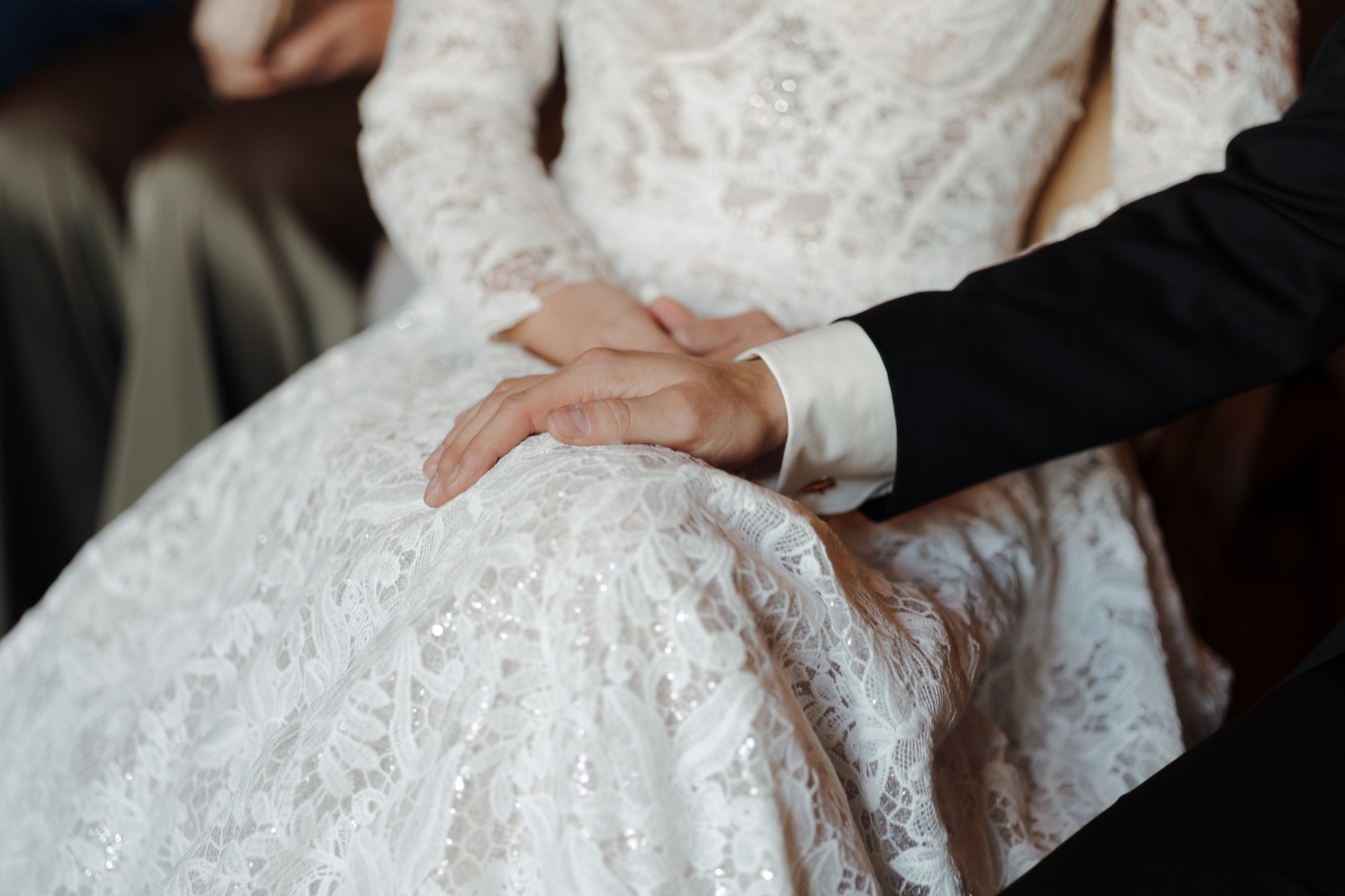 Max’ Hand auf Christines Kleid während der Trauung